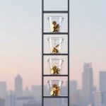 A ladder with four transparent buckets filled with gold coins, positioned vertically. Coins are dripping from the top bucket to the one below. A city skyline is in the blurred background.