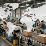 Factory floor with workers sorting boxes on conveyor belts. A transparent world map overlay highlights global logistics.