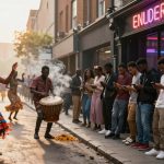Street scene with dancers in colorful traditional attire performing near a drummer. A line of people looks at their phones outside a shop with a neon sign.