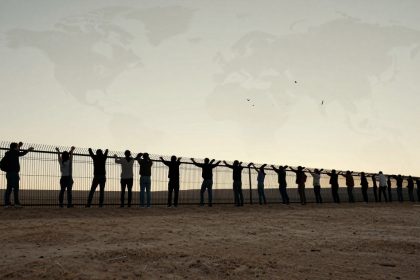 A group of people stand side by side, with hands raised, holding onto a tall fence. The sky is a pale gradient, and a faint world map overlays the background. Birds are visible in the sky.