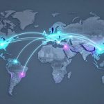 Digital world map with glowing blue and pink nodes connected by light trails, depicting global communication. Silhouettes of people stand on various continents.