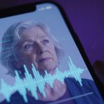 A smartphone screen displays a video of an elderly woman with short gray hair, alongside audio waveforms. The background is purple.