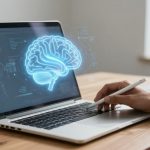 A person uses a stylus on a laptop displaying a glowing holographic brain. The setting is a light-filled room with a wooden table.