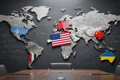 A world map on a blackboard with puzzle pieces representing different countries. The USA is marked with its flag, China with a red piece, NATO with a blue piece, and Ukraine with a blue and yellow piece. Mathematical equations are drawn on the blackboard. A conference table with chairs is in the foreground.