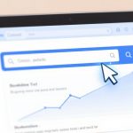 A computer screen displaying a search bar with a blue border, containing the text "Coseo, guifedo" and a search icon. A large cursor points at the search icon. Below, there's a blurred line graph and text.