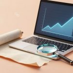 A laptop on a desk displays a graph with an upward trend. A magnifying glass, a rolled parchment, and a cup of coffee are nearby.