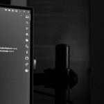 A computer monitor displaying lines of code in a darkened room, illustrating a local AI coding agent running on a developer machine