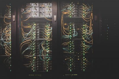 Dense rows of network cables in a data centre, illustrating the AI inference routing layer Stripe is acquiring with OpenRouter